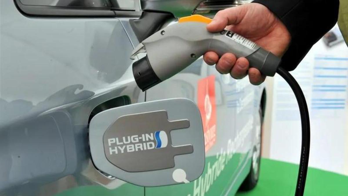 Un hombre conecta un cargador a un coche eléctrico en Estrasburgo (Francia).