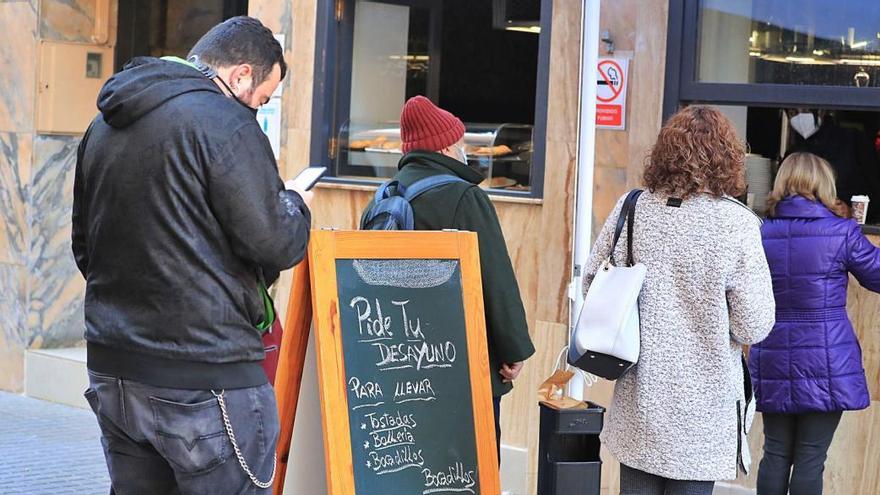 Clientes en cola ante un bar de Cartagena que sirve desayunos para llevar.