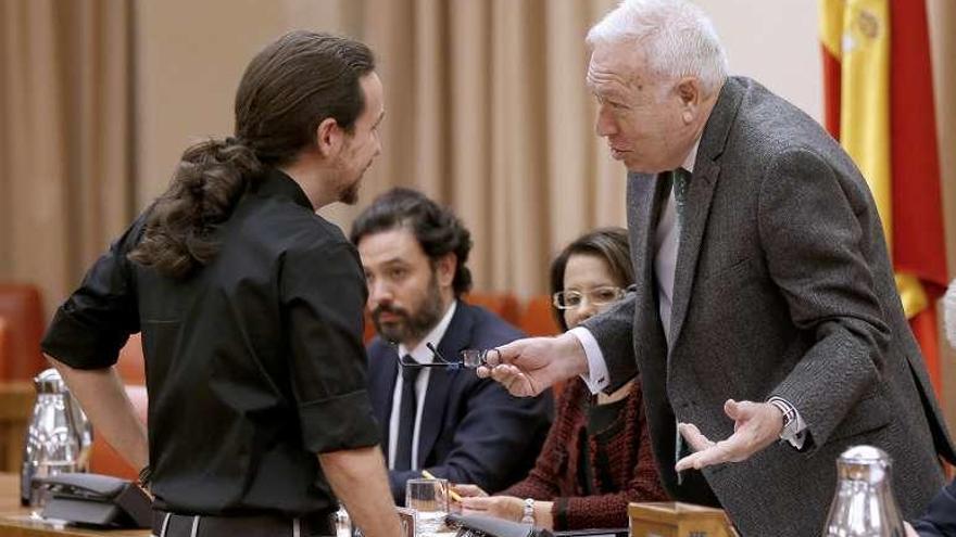 Margallo conversa con el líder de Podemos, Pablo Iglesias, ayer, en la Comisión de Exteriores del Congreso. // Efe