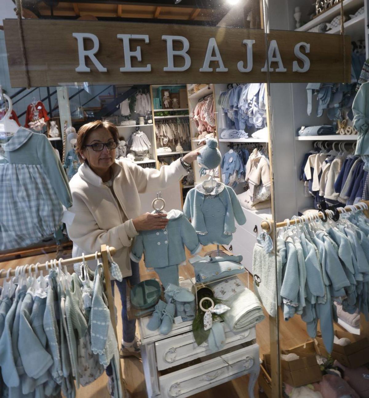 Eva Mesa, en el escaparate de su tienda de ropa para bebés de Avilés.