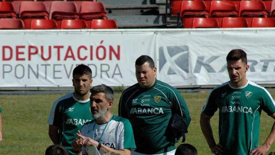 Los jugadores del Coruxo atienden a las explicaciones de Jacobo Montes, ayer en O Vao. // R.R.