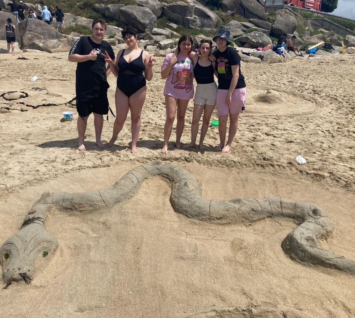 Algunos de los alumnos posan ante una de las obras elaboradas ayer, en la playagrovense de A Lanzada. | // INSTITUTO MONTE DA VILA