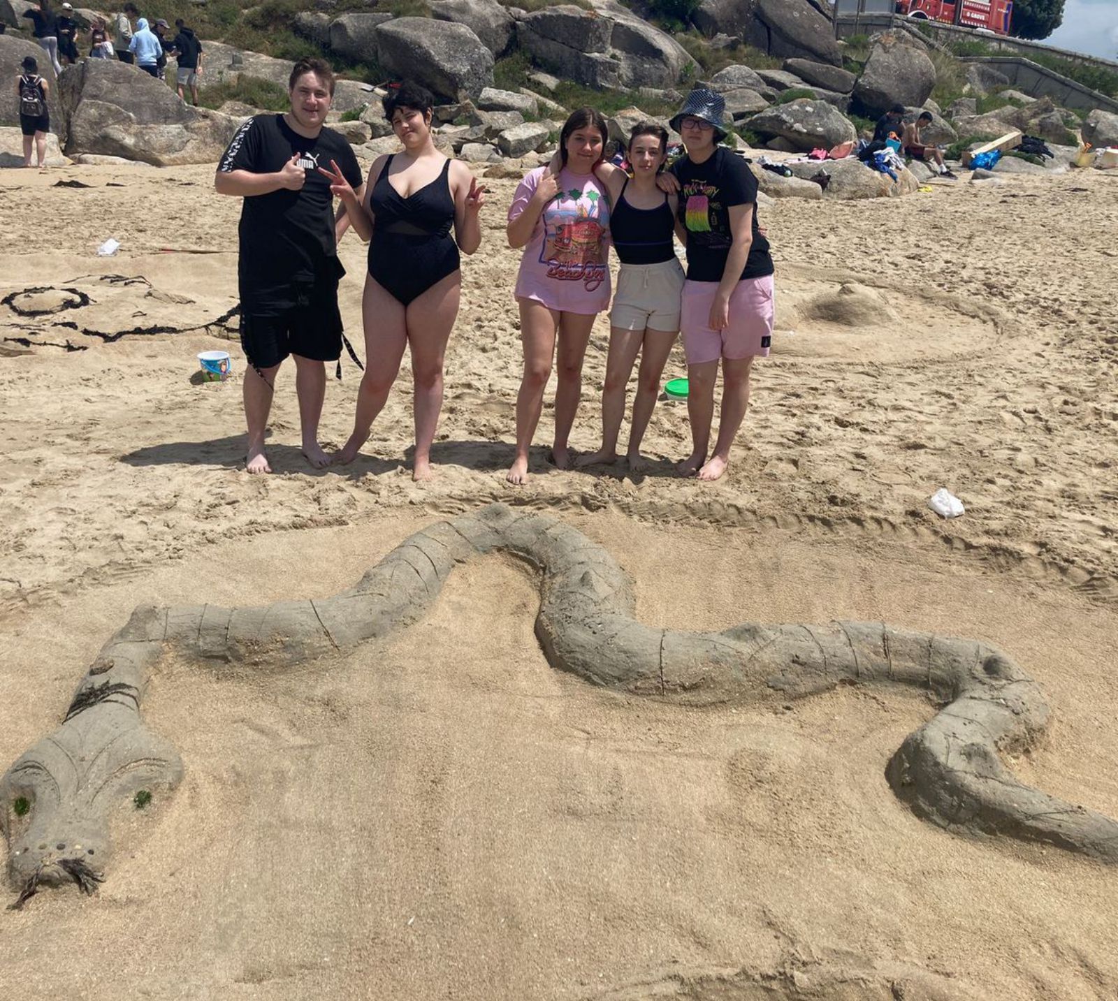 Algunos de los alumnos posan ante una de las obras elaboradas ayer, en la playa grovense de A Lanzada.   | //  INSTITUTO MONTE DA VILA