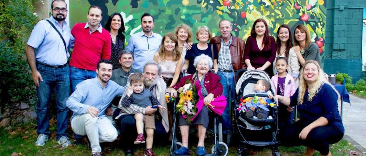 Carolina Prendes Busto, tras cumplir los 100 años, lo celebra bebiendo unos culetes de sidra con la imagen, al fondo, de la Santina, de la que es devota.