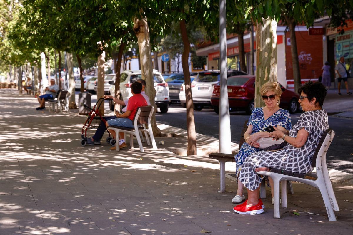 Varias personas descansan en algunos de los bancos de la avenida Gran Vía Parque.
