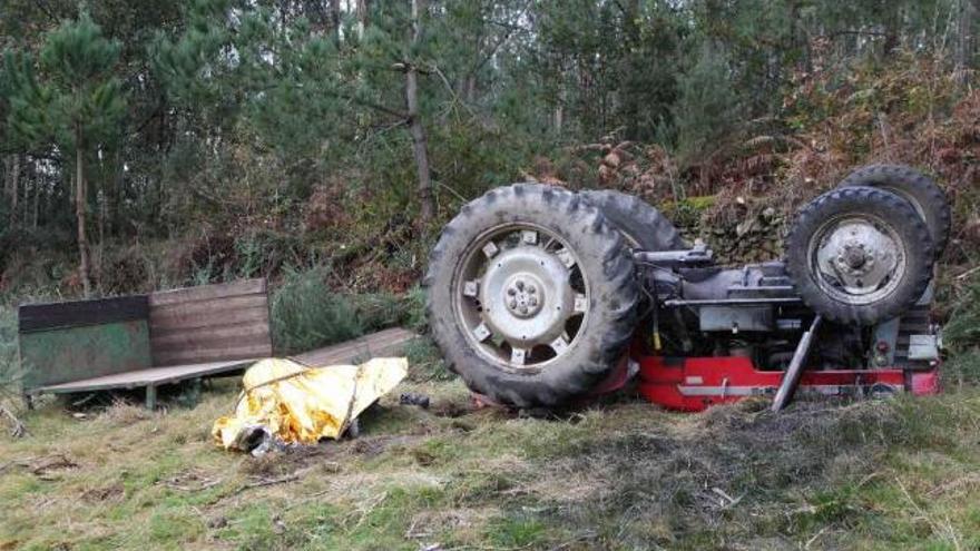 El cuerpo sin vida al lado del tractor después de ser excarcelado por los equipos de emergencia. / l. o.