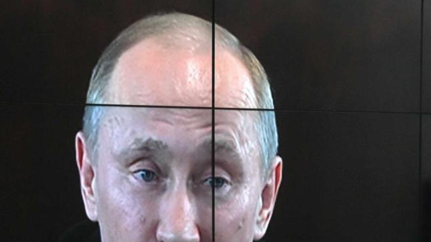 Putin, en videoconferencia en pantalla gigante, desde la sede de su campaña.