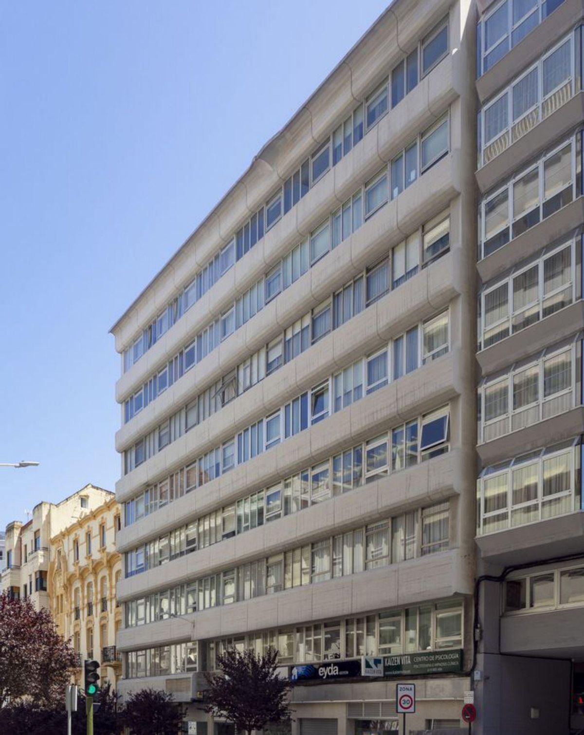 Edificio Pou. Miguel Fisac, 1967. Marcado «por la horizontalidad generada por las bandejas de hormigón curvadas que recorren el inmueble de lado a lado y enmarcan las ventanas en hileras».