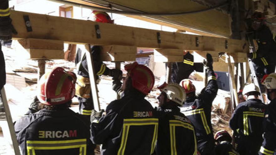 Bomberos apuntalan una pared y el techo de un edificio de Lorca