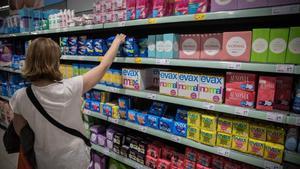 Una mujer escoge tampones en el supermercado.