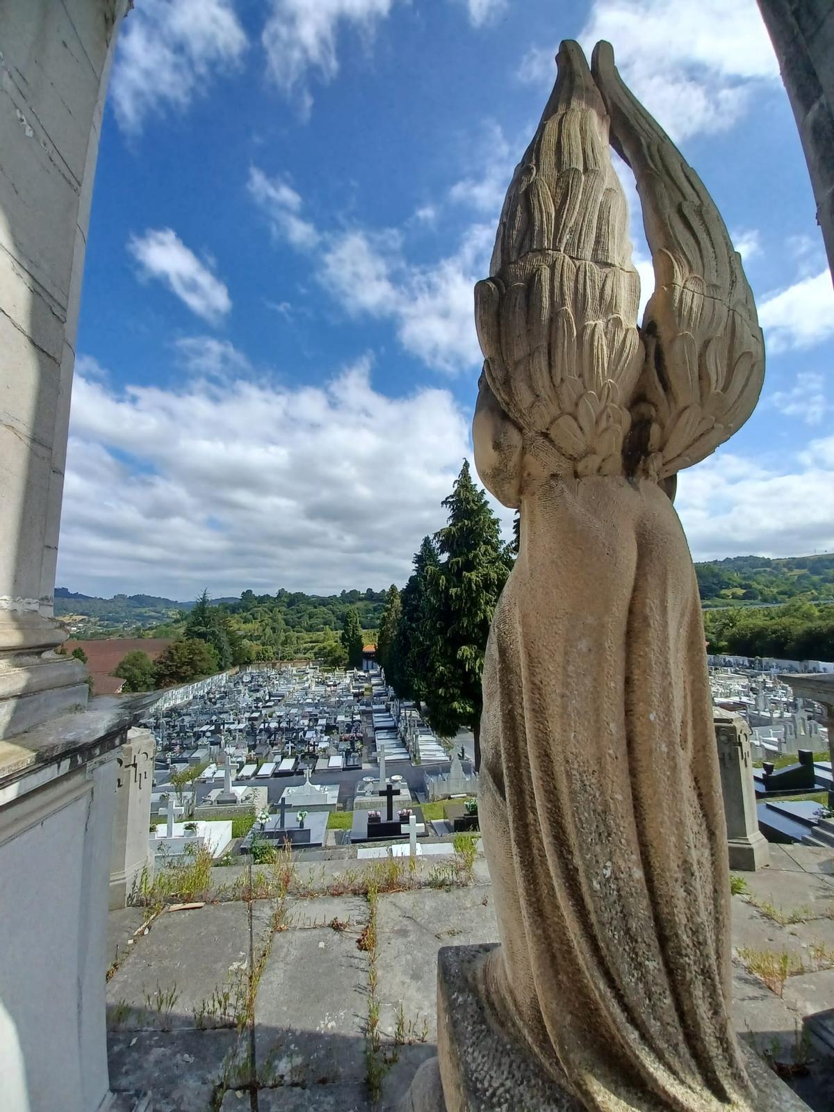 La escultura, vista desde su parte trasera, y el cementerio a sus pies.