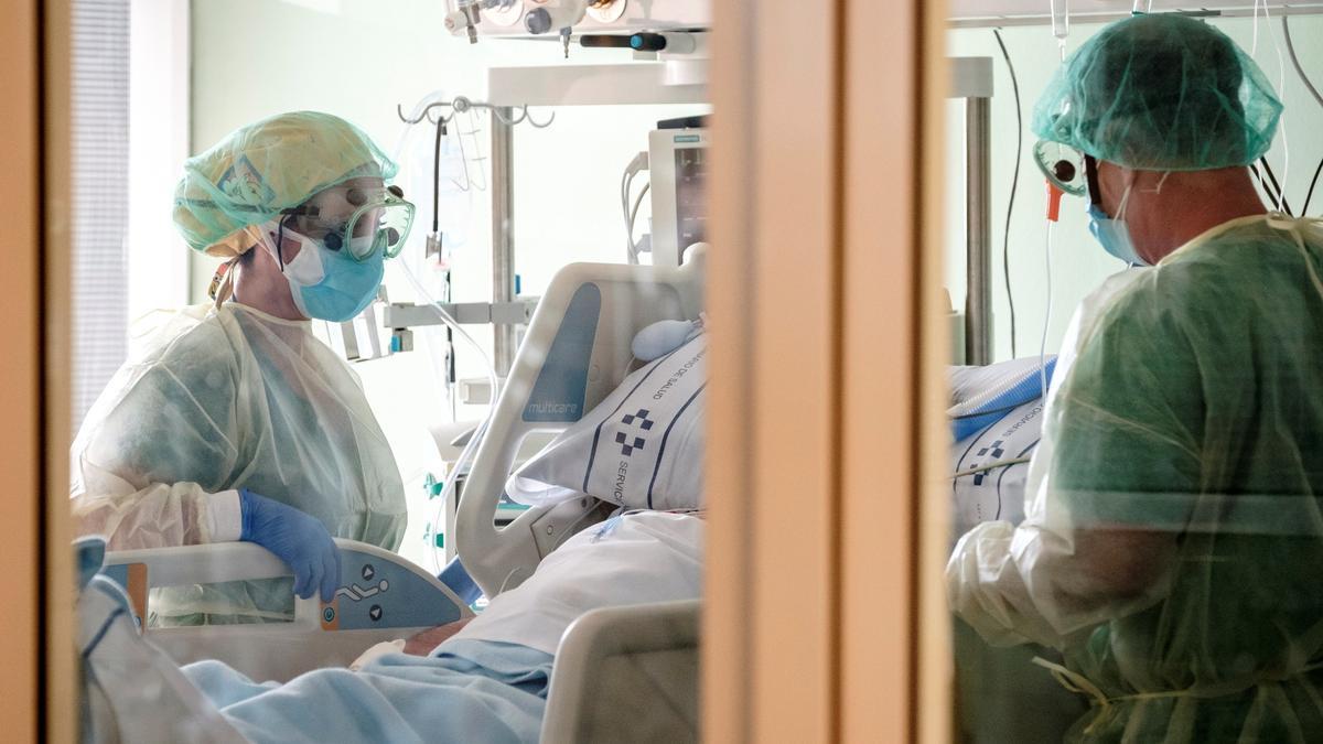 Dos sanitarios atienden a un pacientes con coronavirus en la UMI del Hospital Universitario Insular de Gran Canaria.