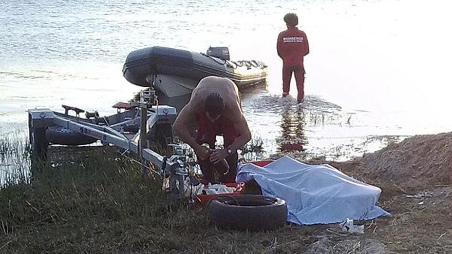 Los bomberos recorren con la lancha las aguas del pantano de Valparaíso.