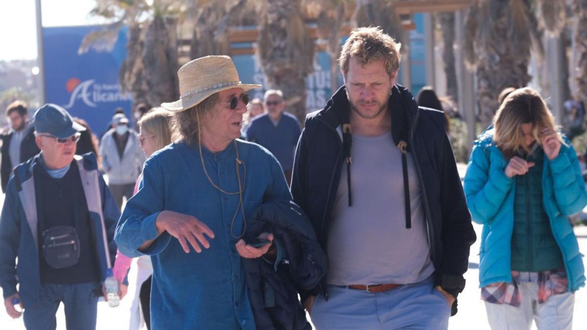 Dos extranjeros conversan mientras pasean  por Playa de San Juan, y viandantes por el centro de Alicante. | ÁXEL ÁLVAREZ/JOSE NAVARRO