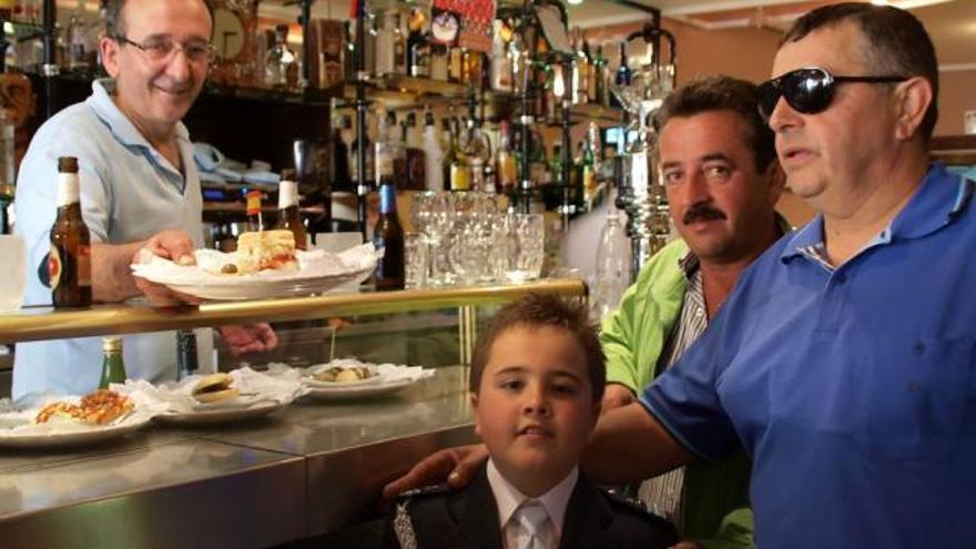 Tres clientes en uno de los bares de la ciudad con las tapas a la vista.