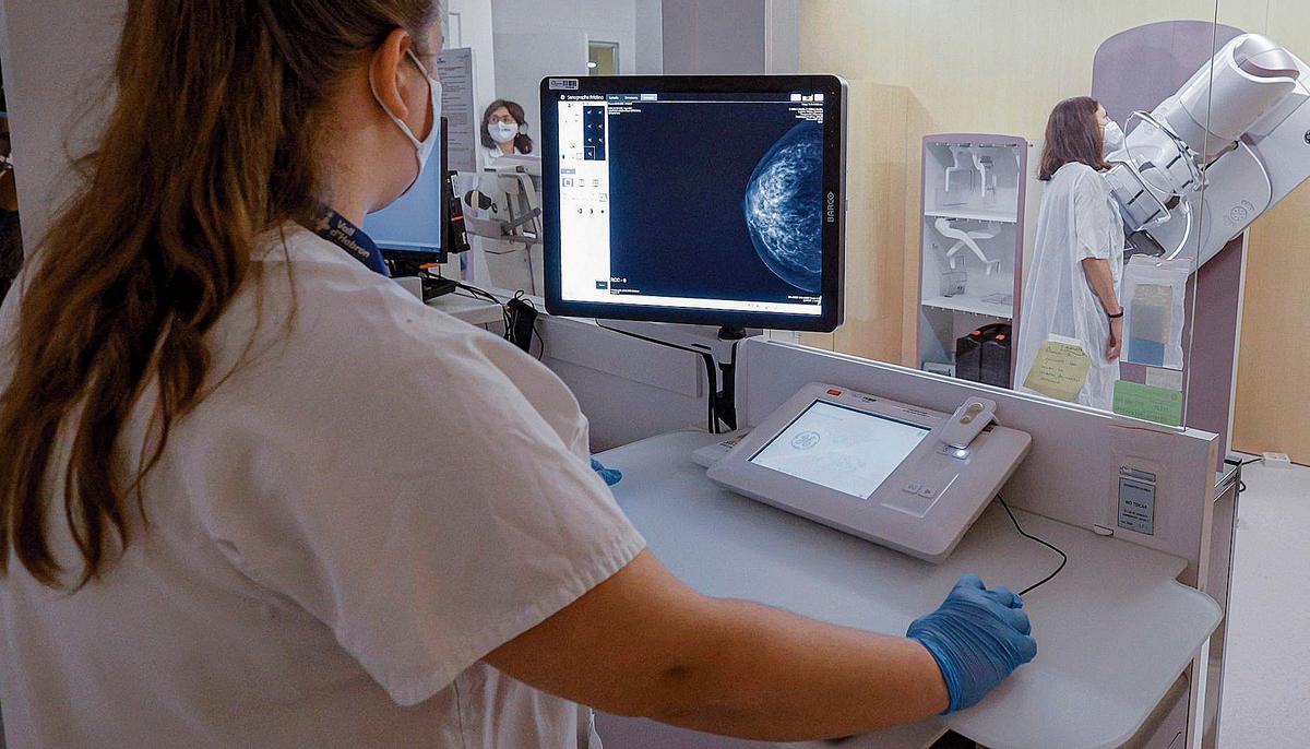 Una enfermera, a la izquierda, observando una mamografía.