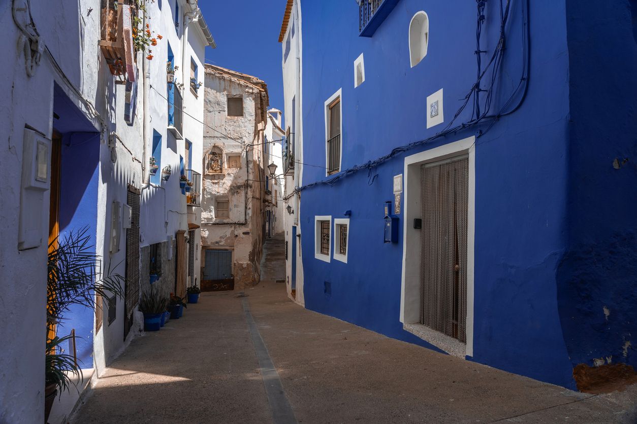 Casas blancas y azules en las calles del barrio musulmán de Benacacira en el precioso pueblo de Chelva en un día soleado, Valencia.
