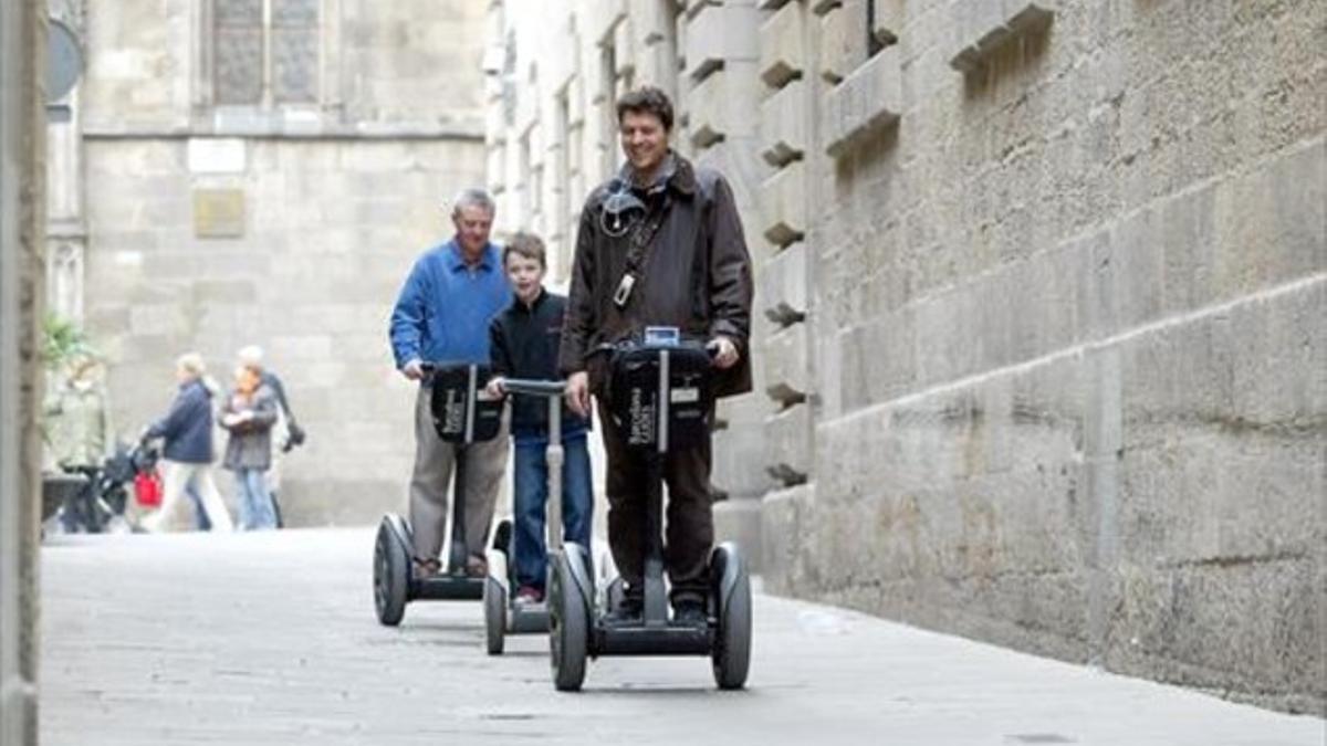 Unos turistas se desplazan en 'segway' por el centro de Barcelona.