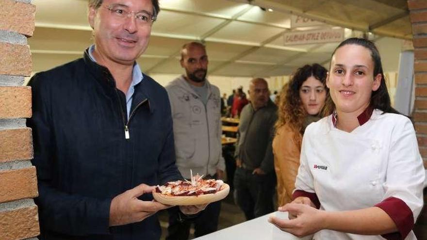 El alcalde, José Cacabelos, recogiendo una ración de pulpo. // Muñiz