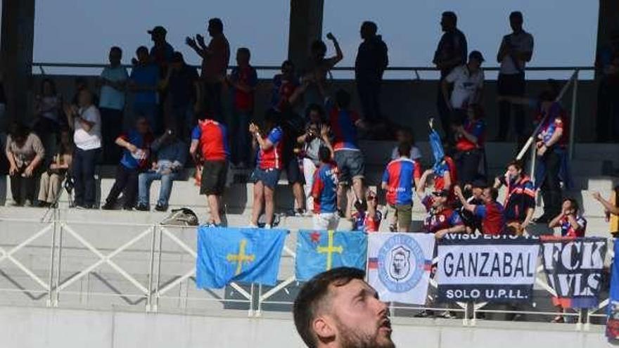 Adrián Torre celebra uno de los goles de su equipo con aficionados del Langreo al fondo de la imagen.