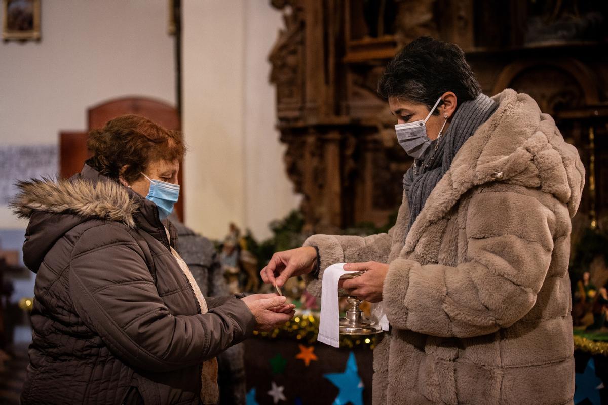 La animadora de la Palabra reparte la comunión en la Iglesia de Cantiveros.