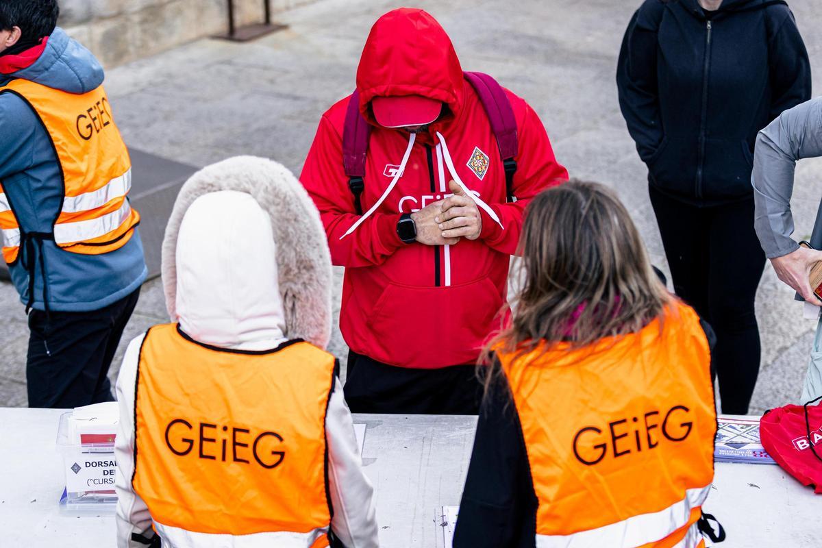 Un participant de la Pujada a peu als Àngels recull el dorsal.