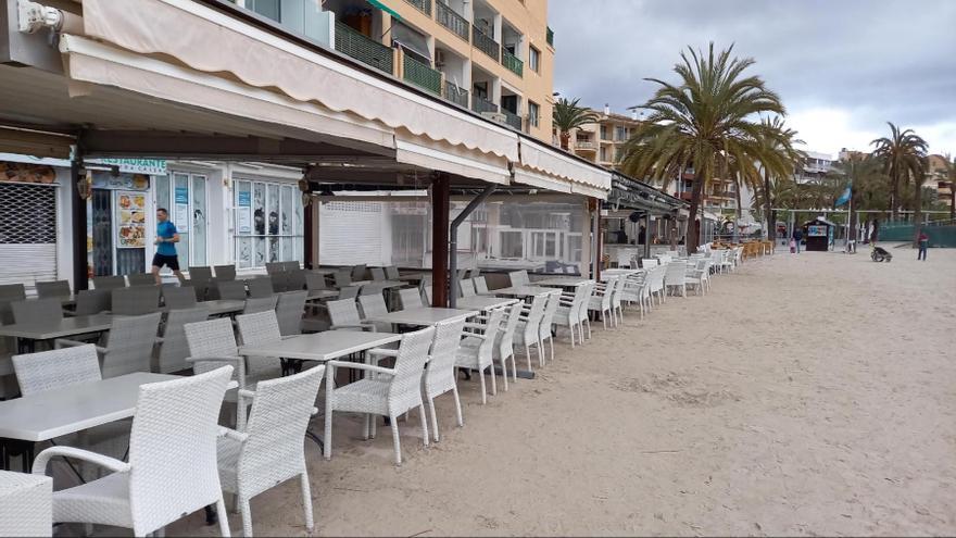 Terrazas de bar sobre la arena en el puerto de Alcúdia.