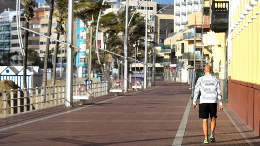 Un vecino camina por el paseo de Las Canteras.