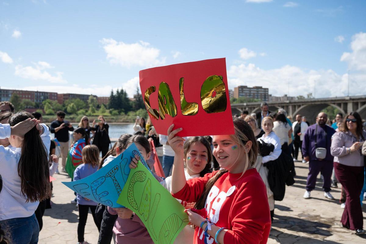 Los niños alzan las pancartas en la ceremonia del río