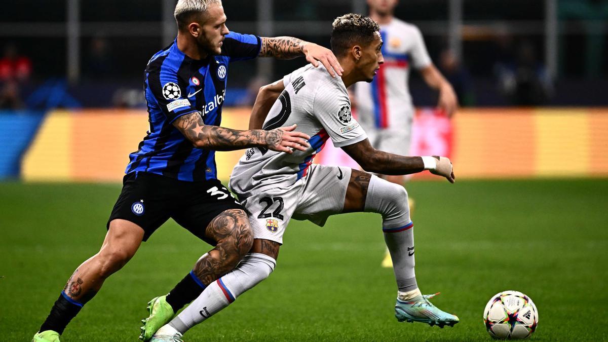 Raphinha supera al defensor italiano del Inter de Milán, Federico Dimarco durante el partido entre el Inter de Milán y el FC Barcelona.