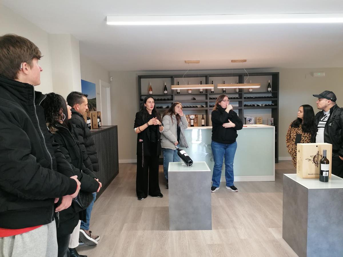 Participanten en la visita atienden a las explicaciones de Guerra y de la intérprete.