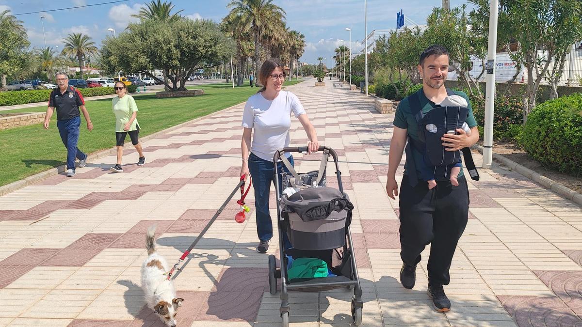 Una familia, con su mascota, en pleno paseo marítimo de Canet.