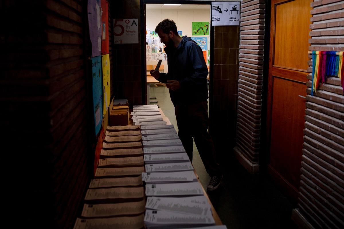 MADRID, 28/05/2023.-Un votante elige su opción en un colegio electoral de Madrid durante comicios de este 28M, este domingo. Cerca de 35,5 millones de ciudadanos votan este domingo a los representantes de unos 8.100 municipios de España en una elecciones muy reñidas en las que también se renuevan 12 gobiernos autonómicos, además de las asambleas de las ciudades autónomas de Ceuta y Melilla, cabildos insulares y otras entidades territoriales. EFE/Daniel González