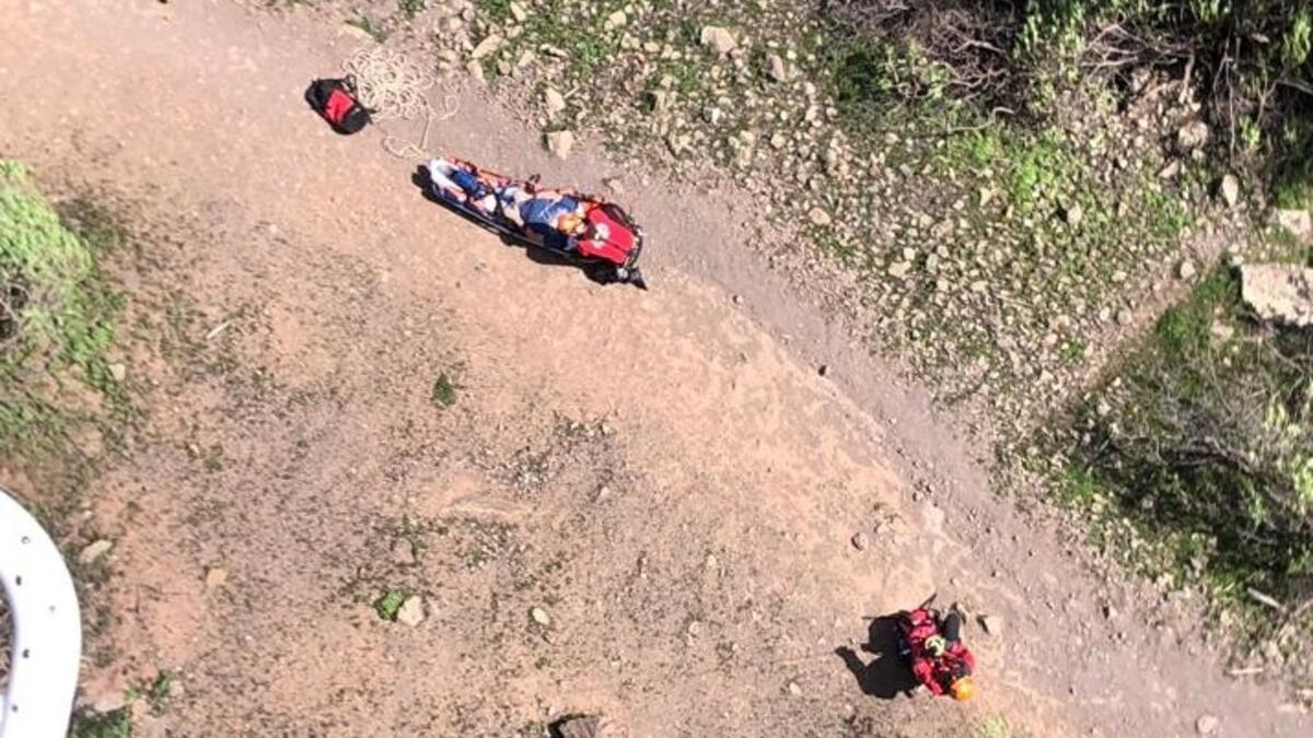 Momento de la evacuación en helicóptero del senderista herido en el barranco de Los Cernícalos, en Telde.
