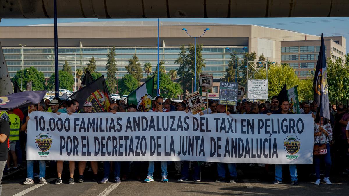 Concentración del sector del taxi en la parada del Estadio de la Cartuja, punto de inicio de una marcha a pie hasta las puertas del Parlamento andaluz en protesta por la regulación que prepara la Junta para los VTC.