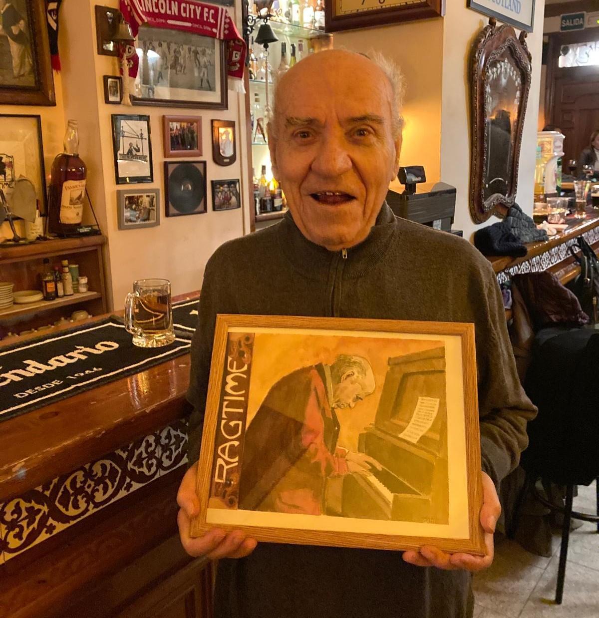 25 de enero de 2023: Domingo Belled, en su 90 cumpleaños, sostiene en el Ragtime una acuarela dedicada a él realizada por el artista Nacho Rúa