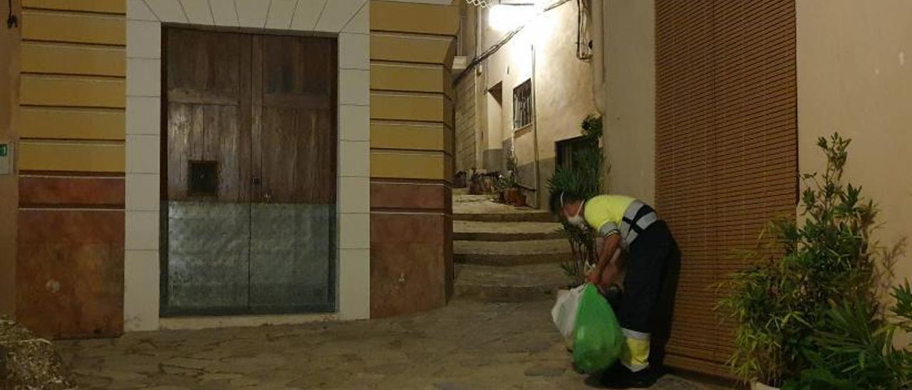 Un operario recoge la basura en la puerta de un domicilio del barrio medieval de Bocairent.  | LEVANTE-EMV