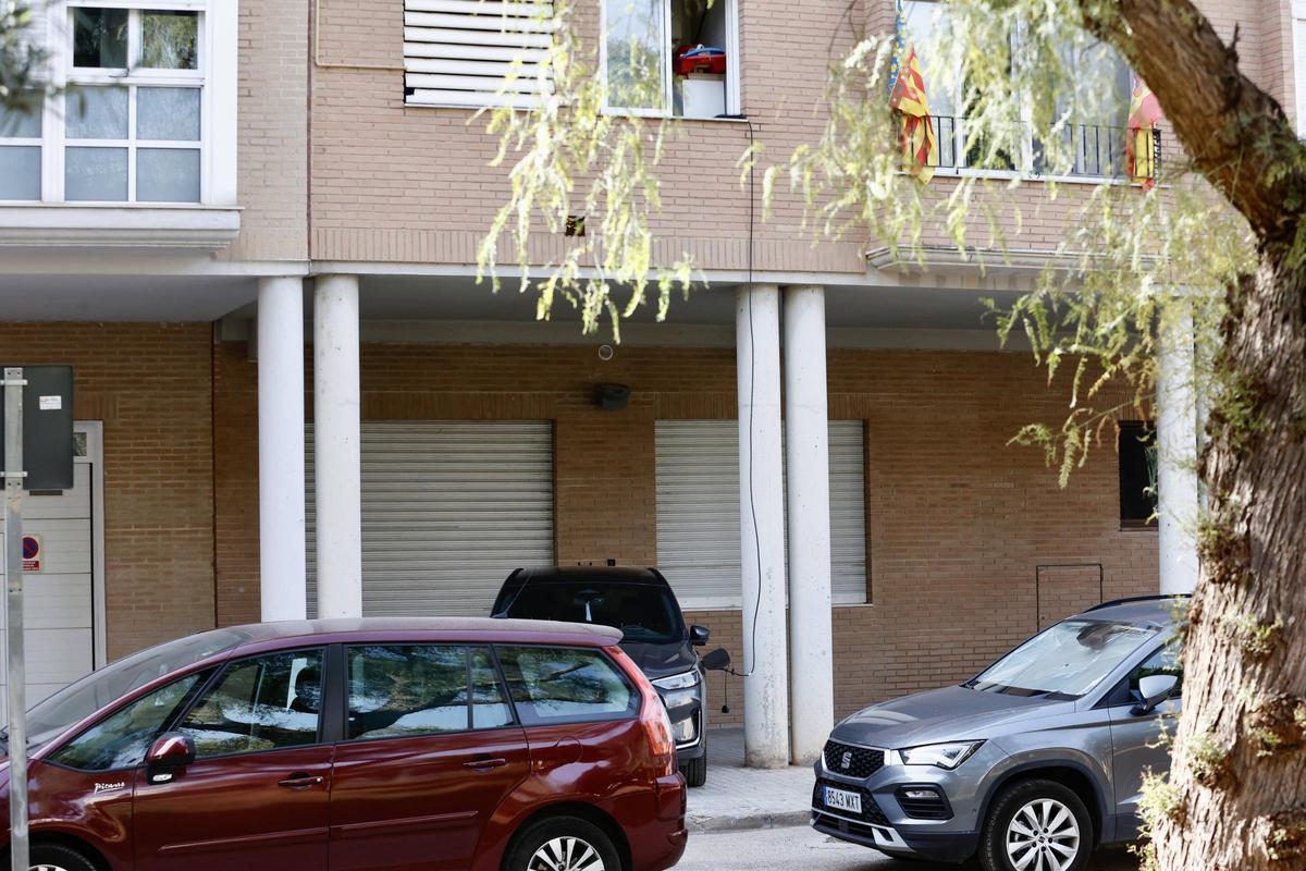 Un coche eléctrico recibe la carga desde un cable colgado por la ventana de un segundo piso en Catarroja.
