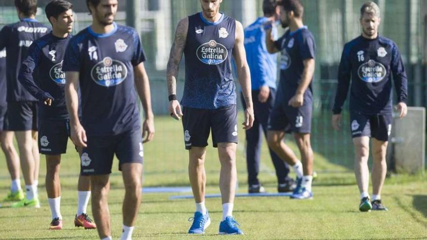 Raúl Albentosa, en el centro, se retira junto a varios compañeros de la sesión de recuperación de ayer en Abegondo.