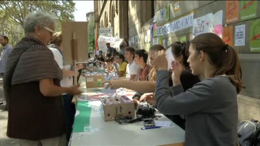 Estudiantes de la Universidad de Barcelona reparten papeletas para votar el 1-0