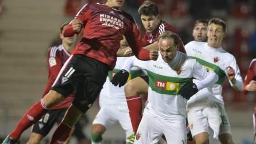 Un defensa del Mirandés despeja la pelota ante Nino. Una imagen que define el partido, querer y no poder por parte del Elche.