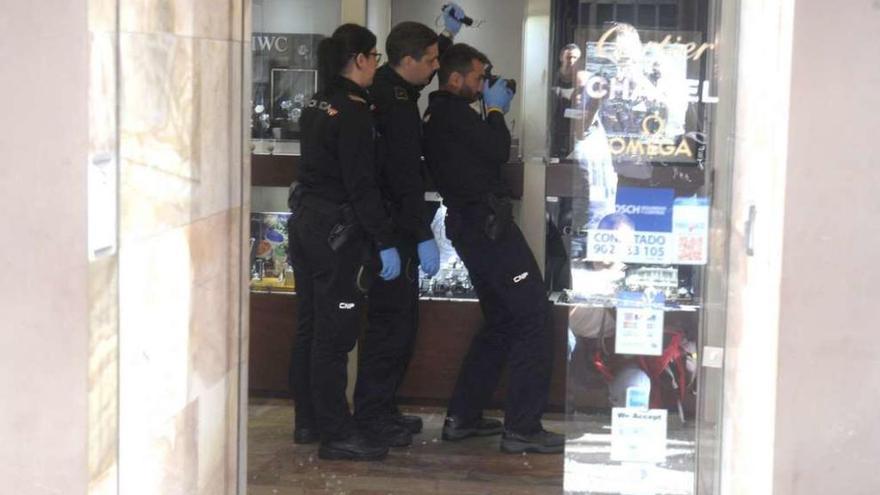 Tres agentes de la Policía Nacional, durante la investigación de un robo en una joyería del centro.