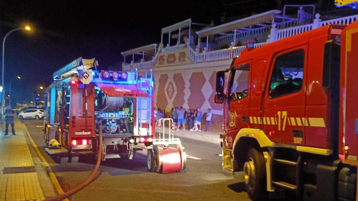 Efectivos de bomberos y residentes desalojados tras el incendio en un complejo turístico de Tenerife.