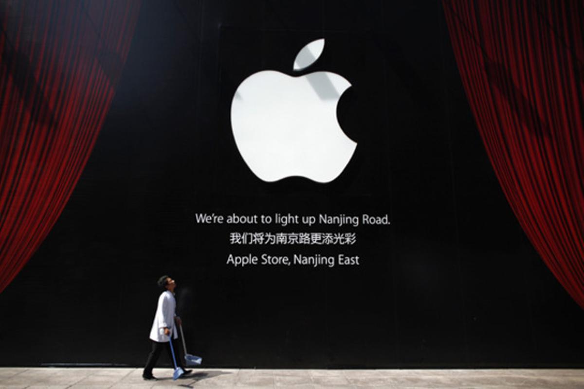 Un treballador camina al costat de la tercera botiga Apple, que obrirà a l’octubre a Xangai (Xina).