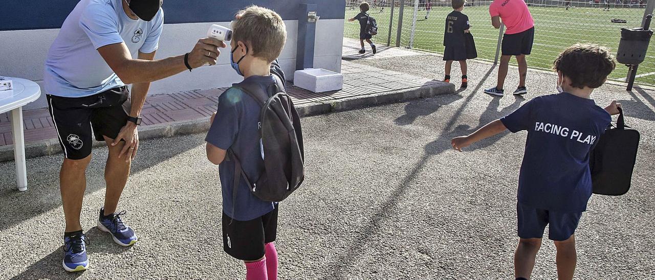 Un técnico toma la temperatura antes de un entrenamiento de un equipo infantil en el Cabo. | PILAR CORTÉS