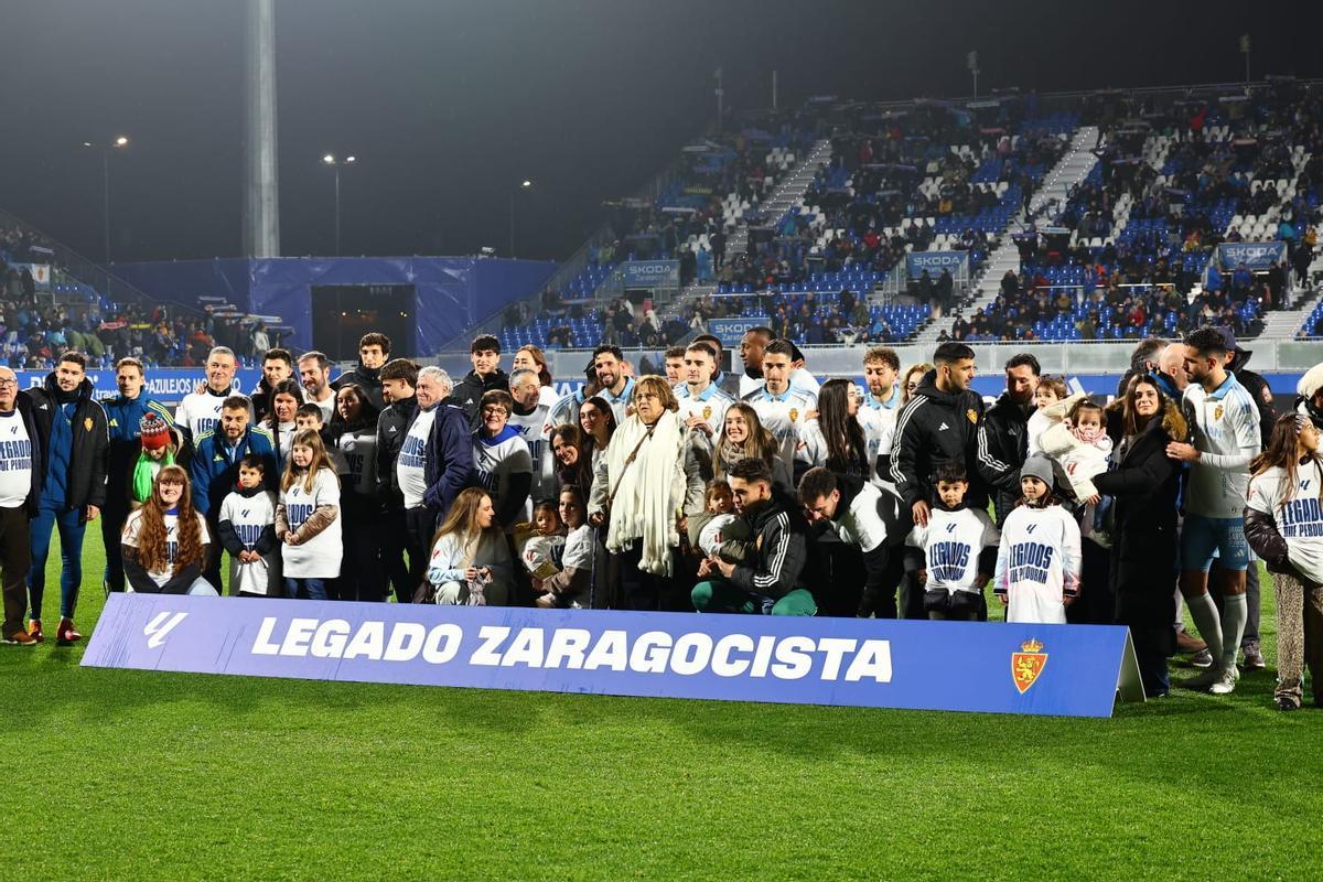 El once zaragocista y un grupo de aficiondos posan antes del partido con las gradas vacías a la espalda.