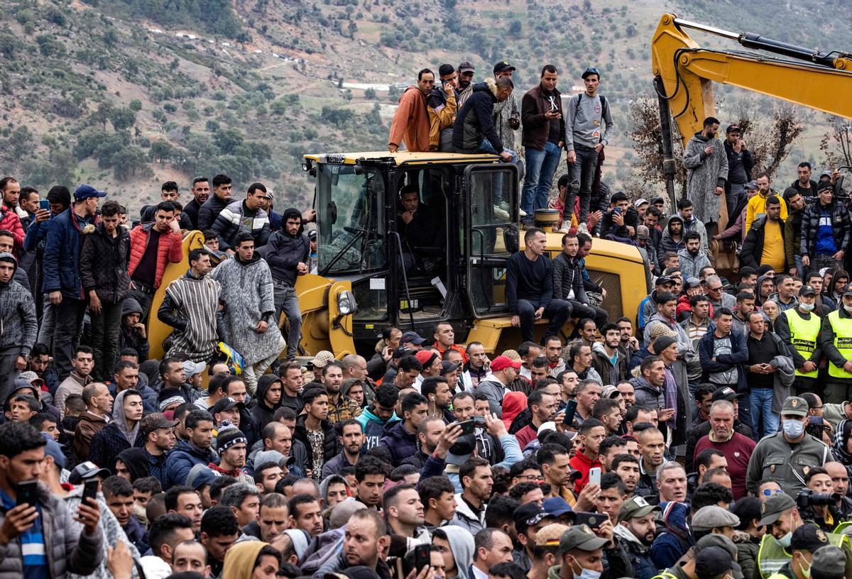 La gente observa cómo los equipos de los servicios de emergencia marroquíes trabajan en el rescate de Rayan , un niño de cinco años, de un pozo en el que cayó el 1 de febrero, en la remota aldea de Ighrane, en la provincia rural del norte de Chefchaouen, el 5 de febrero de 2022. - Los rescatistas marroquíes trabajaron durante la noche, el quinto día de un esfuerzo cada vez más urgente y angustioso para rescatar a Rayan , un niño de cinco años atrapado bajo tierra en un pozo. (Foto de Fadel SENNA / AFP)on Fotos 1-139232237.jpg