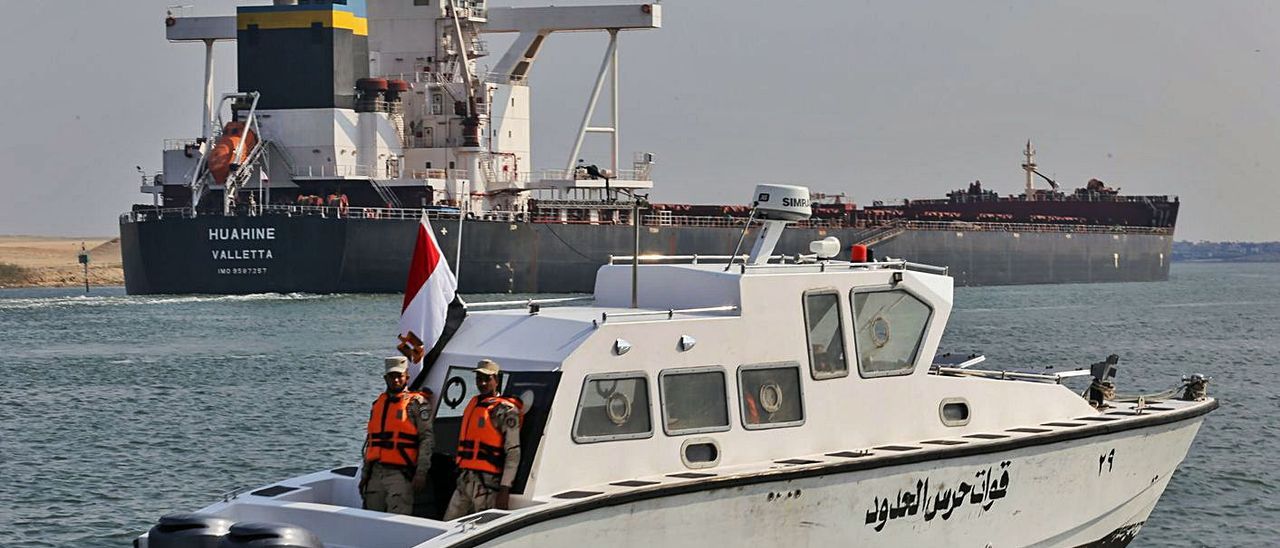 Un barco de patrulla egipcio, junto a un mercante, ayer, en el canal de Suez.