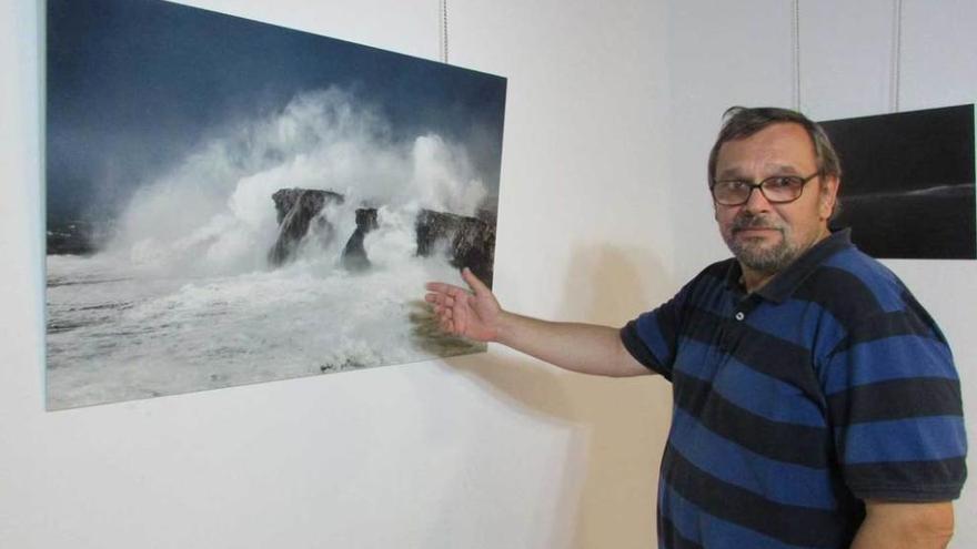 Fernández junto a una imagen del temporal en los bufones de Pría.