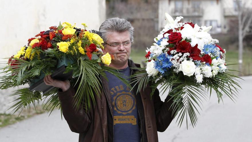Un vecino lleva un ramo de flores en recuerdo a las víctimas.